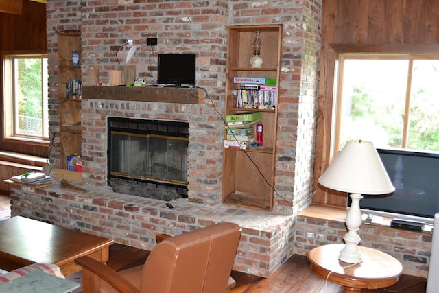 375 Flintside Dr, Cobb, GA 31735 - living area featuring wood finished floors, a brick fireplace, and wood walls