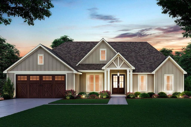 view of front of home featuring a garage, a yard, and french doors