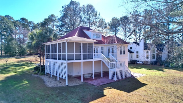 back of house with a sunroom and a lawn