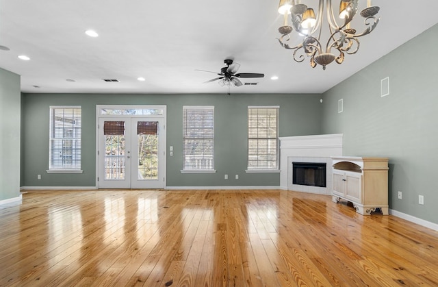 unfurnished living room with light wood-type flooring, ceiling fan, and a fireplace