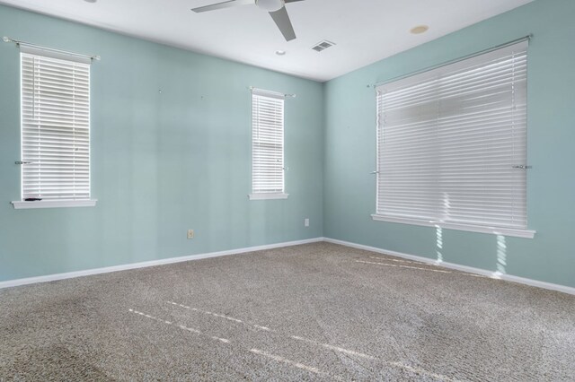 carpeted spare room with ceiling fan