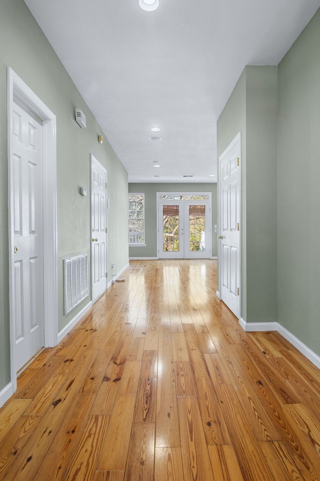 unfurnished living room featuring light hardwood / wood-style flooring and french doors