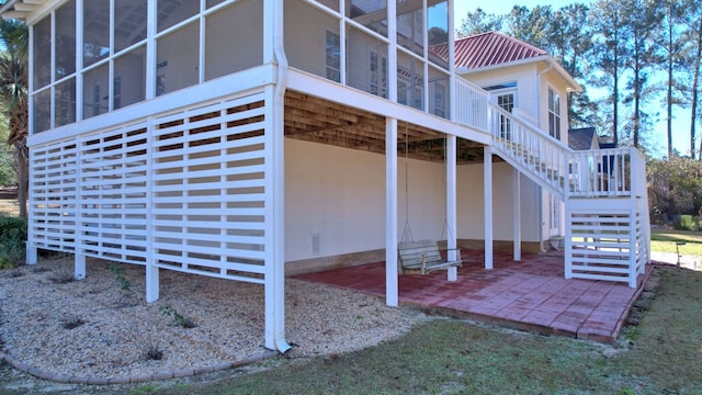 view of side of home with a patio and a sunroom