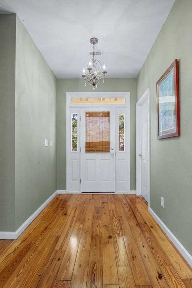 entryway with a chandelier and light hardwood / wood-style flooring