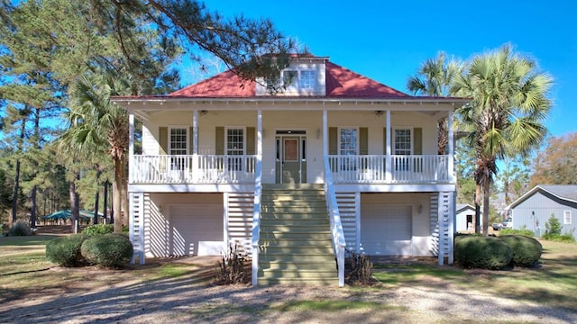 coastal inspired home featuring a garage and covered porch