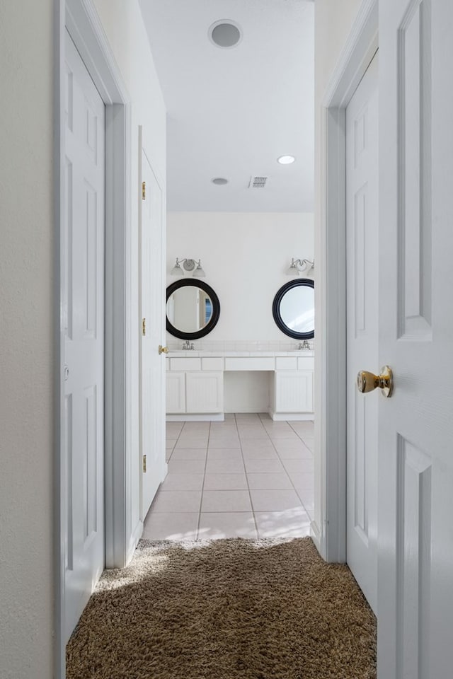 hall with light colored carpet