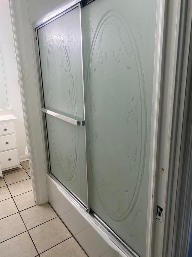 bathroom with an enclosed shower and tile patterned flooring
