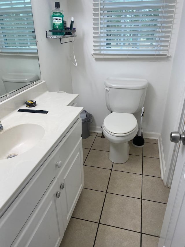 bathroom with toilet, tile patterned floors, and baseboards