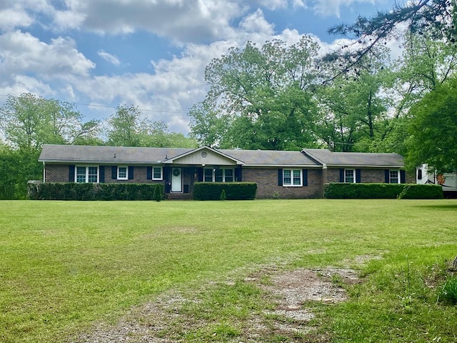 ranch-style home featuring brick siding and a front lawn