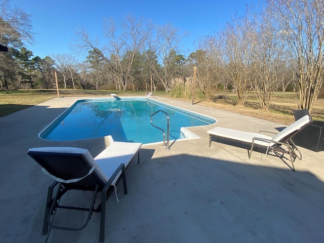 outdoor pool featuring a diving board and a patio area