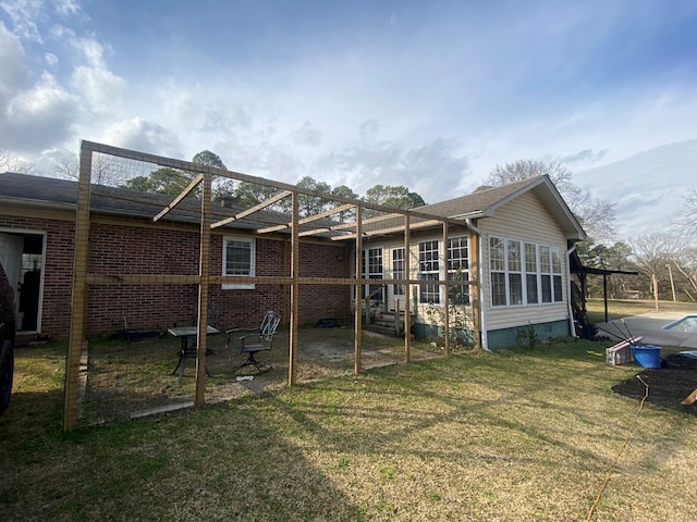 back of house featuring a yard and brick siding