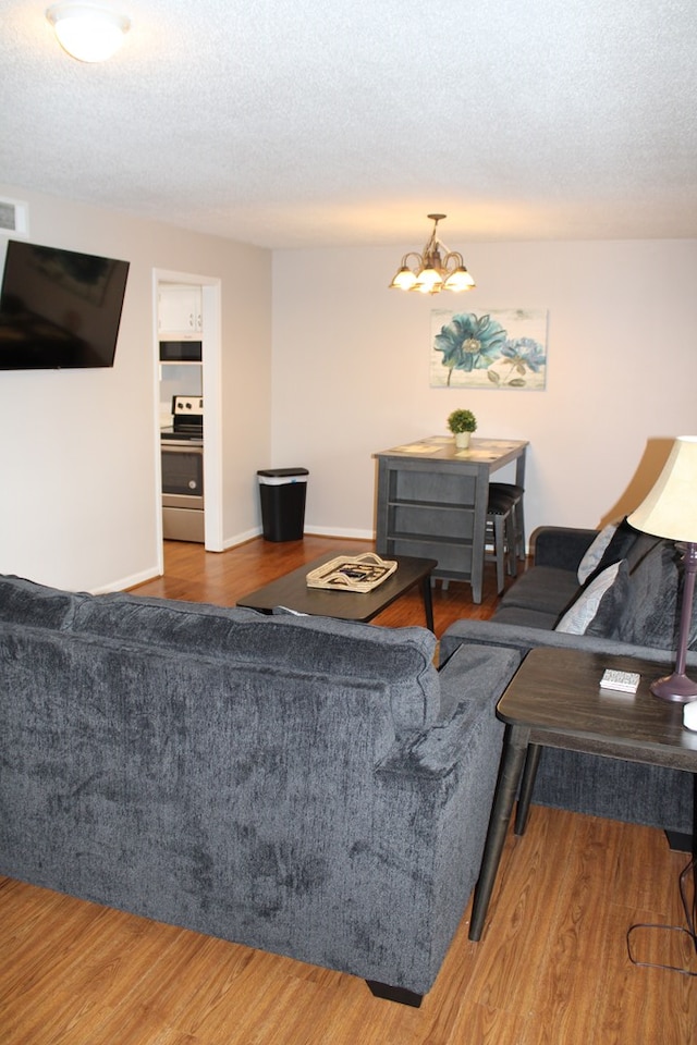 101F Country Club Dr, Americus, GA 31709 - living area featuring wood finished floors, a chandelier, and a textured ceiling