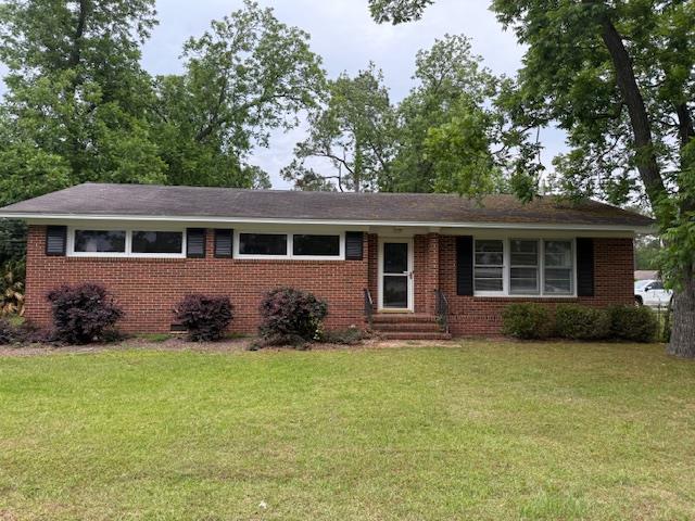 single story home with a front yard, entry steps, and brick siding