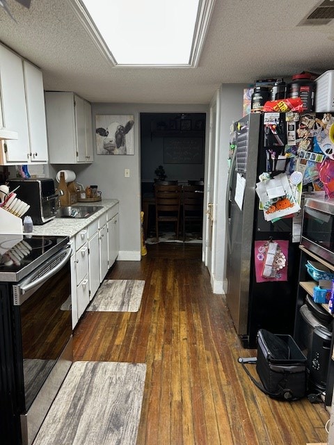 169 Wanda Rd, Cordele, GA 31015 - kitchen featuring stainless steel appliances, a sink, dark wood-style floors, white cabinets, and light countertops