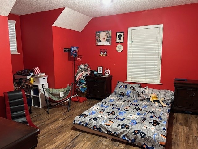 169 Wanda Rd, Cordele, GA 31015 - bedroom with wood finished floors, vaulted ceiling, and a textured ceiling
