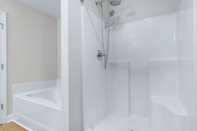 bathroom featuring walk in shower, hardwood / wood-style floors, and a textured ceiling