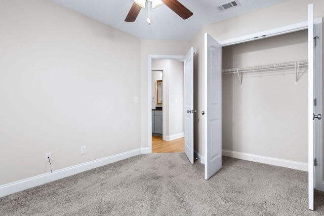 unfurnished bedroom with light colored carpet, a closet, and ceiling fan