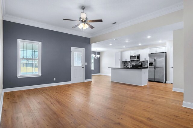 kitchen with backsplash, white cabinets, ornamental molding, and stainless steel appliances