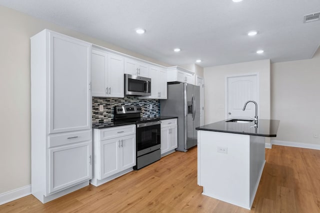 kitchen with sink, white cabinetry, a center island with sink, and appliances with stainless steel finishes