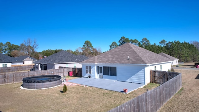 rear view of property featuring a patio area, a fenced in pool, and a yard