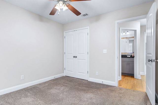 unfurnished bedroom with light carpet, a closet, and ceiling fan