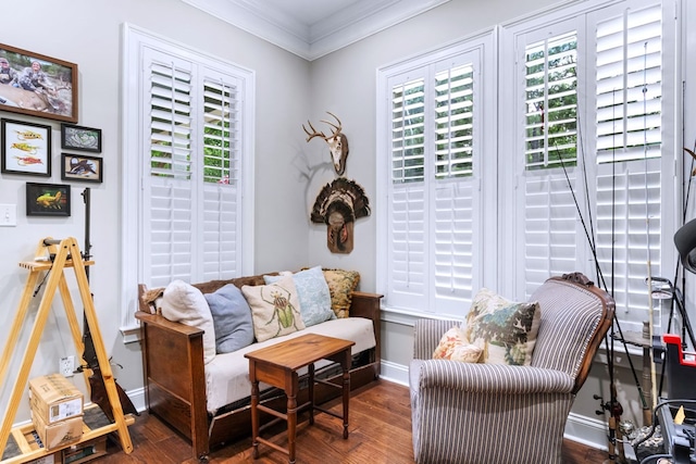 sitting room with crown molding, dark wood-type flooring, and a healthy amount of sunlight