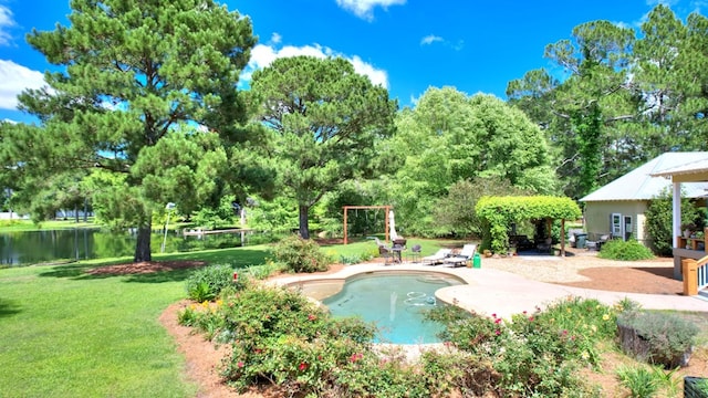 view of swimming pool featuring a yard, a patio area, and a water view