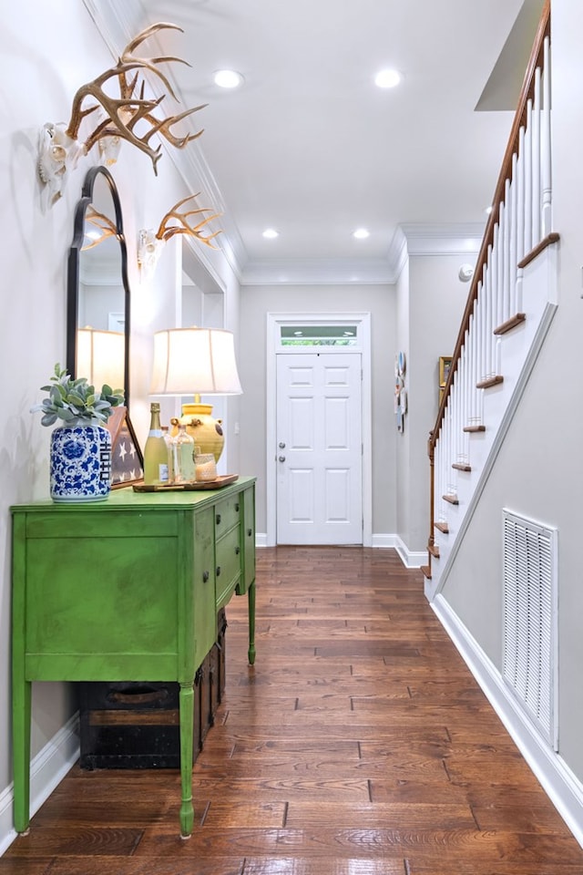 entryway with dark wood-type flooring and ornamental molding