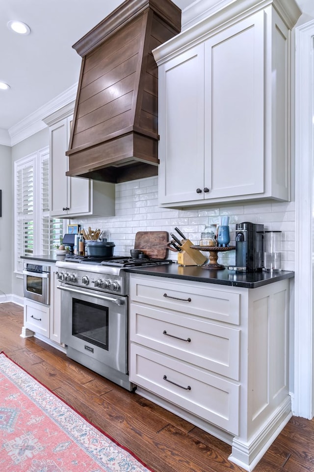 kitchen featuring premium range hood, ornamental molding, dark hardwood / wood-style flooring, stainless steel appliances, and backsplash