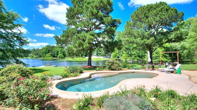 view of pool with a water view, a patio, and a lawn