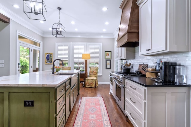 kitchen featuring white cabinets, custom range hood, stainless steel range, and decorative light fixtures