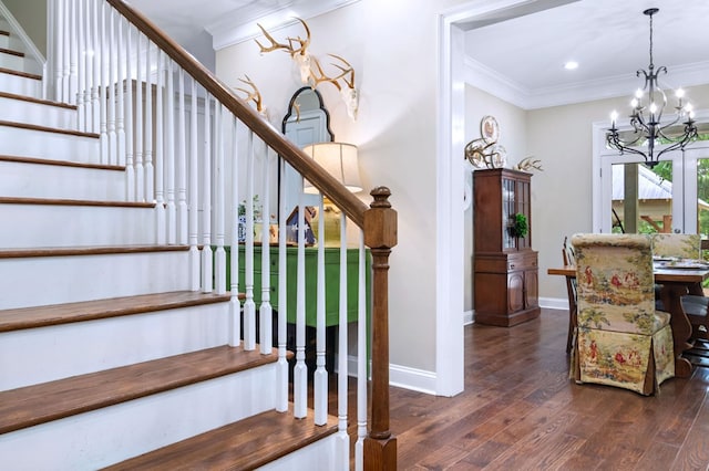 stairs featuring ornamental molding, hardwood / wood-style floors, and an inviting chandelier