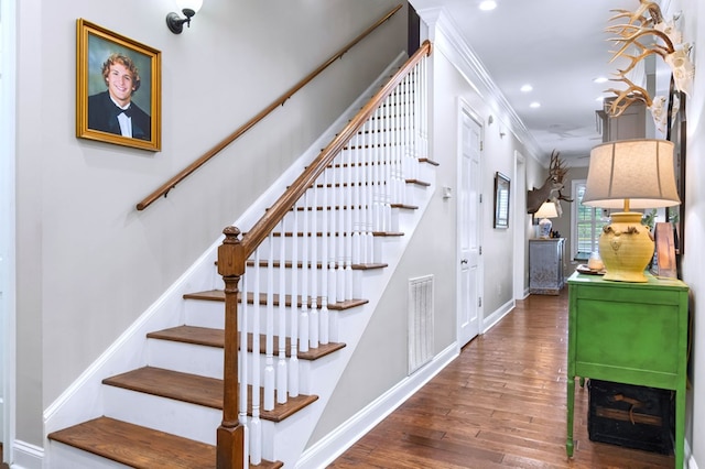 stairs featuring hardwood / wood-style flooring and crown molding