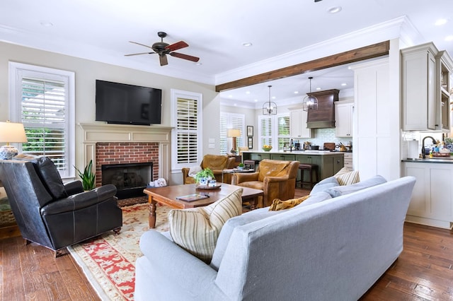 living room with a fireplace, ornamental molding, dark hardwood / wood-style floors, and ceiling fan