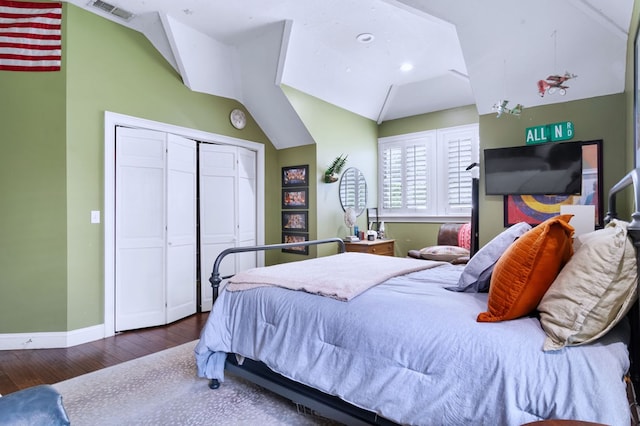 bedroom featuring vaulted ceiling, dark hardwood / wood-style floors, and a closet