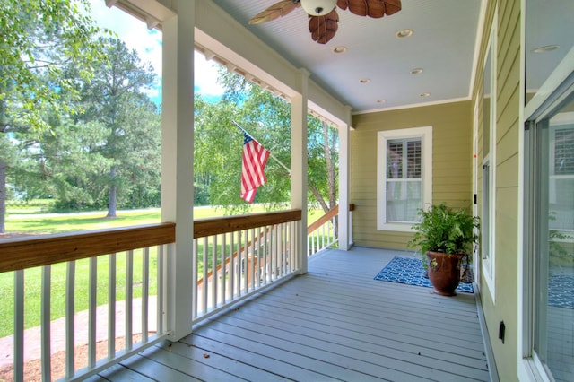 wooden terrace with a lawn and ceiling fan