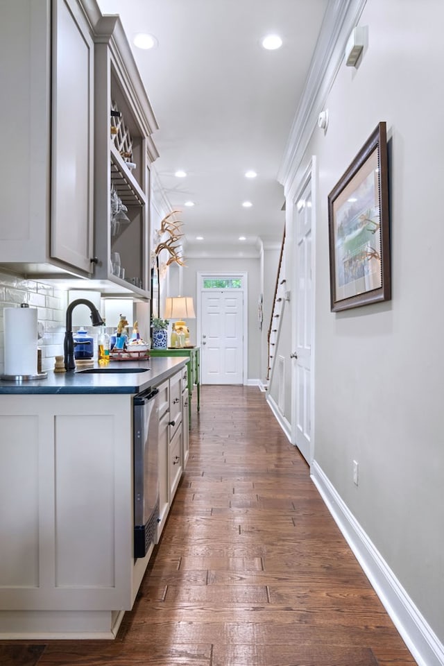 kitchen featuring gray cabinets, dishwasher, sink, dark hardwood / wood-style flooring, and ornamental molding