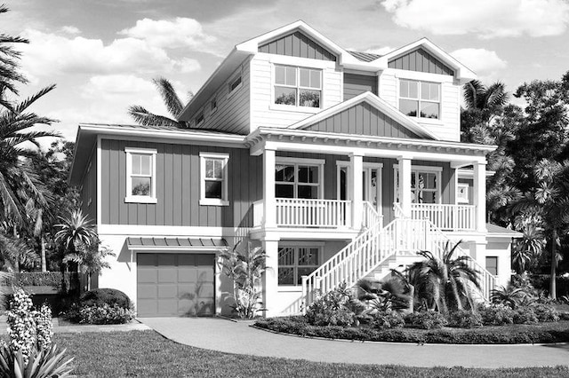 raised beach house with board and batten siding, a porch, stairs, a garage, and a standing seam roof