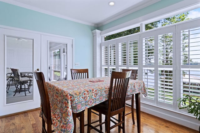 dining area with ornamental molding and wood finished floors