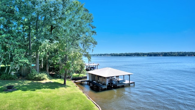 dock area with a water view, a yard, and boat lift