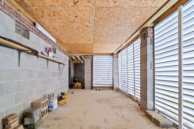 miscellaneous room featuring concrete flooring and concrete block wall