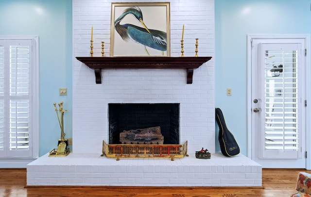 interior details featuring a brick fireplace and wood finished floors