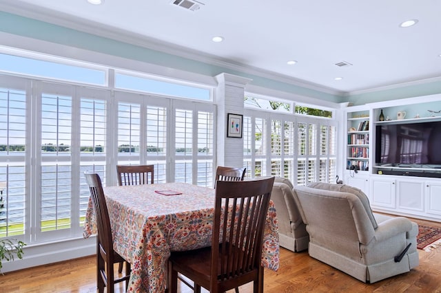 dining area featuring light wood-style floors, recessed lighting, visible vents, and ornamental molding