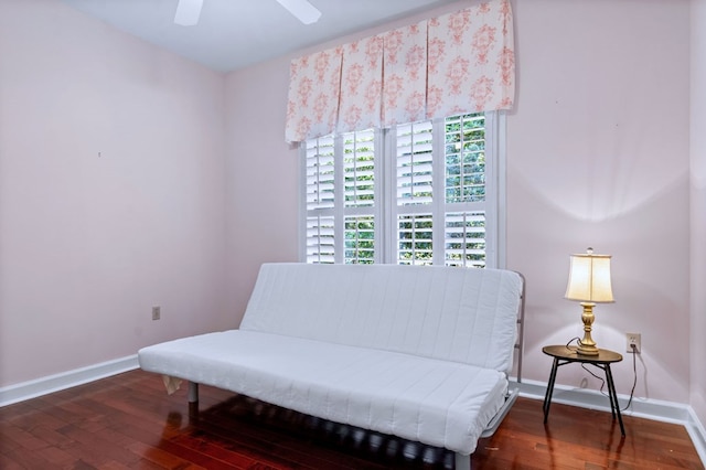 living area with dark wood-style floors, a ceiling fan, and baseboards