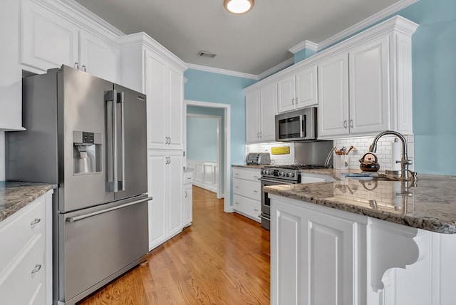 190 Scenic Rt, Cordele, GA 31015 - kitchen featuring stainless steel appliances, a sink, white cabinets, light wood finished floors, and tasteful backsplash