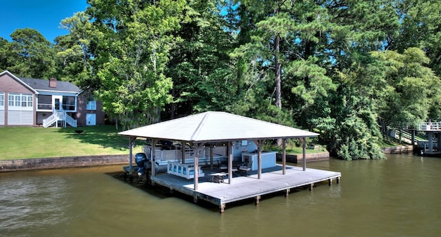 dock area with a water view, boat lift, stairs, and a lawn