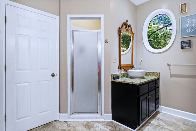 full bath with a stall shower, vanity, and baseboards