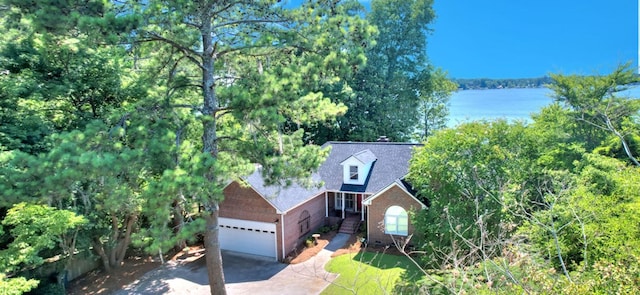 view of front of property featuring a water view, driveway, a garage, and brick siding