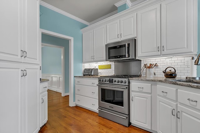 190 Scenic Rt, Cordele, GA 31015 - kitchen with stainless steel appliances, crown molding, white cabinets, backsplash, and light stone counters
