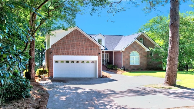 view of front of home with a front lawn, concrete driveway, brick siding, and an attached garage